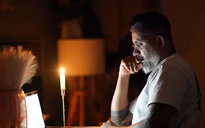 A business owner at his desk late at night, staring at his laptop