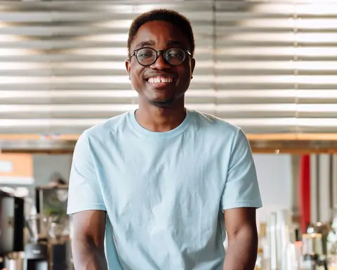 A cafe owner smiling behind his counter